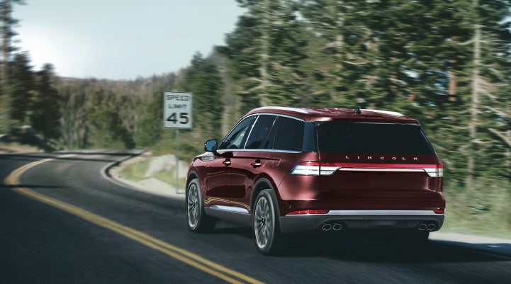 A 2024 Lincoln Aviator® SUV is being driven on a winding mountain road | Krenzen Lincoln in Duluth MN