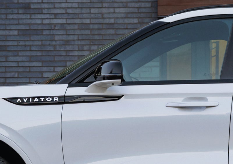 The driver’s side door and fender badging of a white 2026 Lincoln Aviator® SUV are showcased. | Krenzen Lincoln in Duluth MN