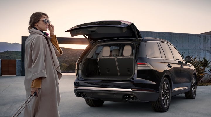 A woman approaches a 2026 Lincoln Aviator® SUV with its rear liftgate open. | Krenzen Lincoln in Duluth MN