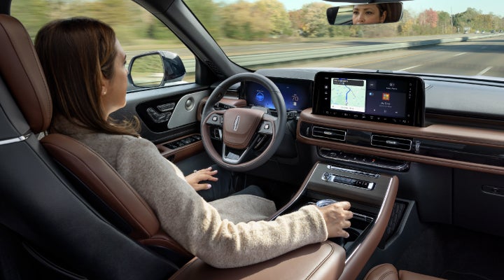A 2026 Lincoln Aviator® SUV is being driven hands-free on a highway near a forest | Krenzen Lincoln in Duluth MN