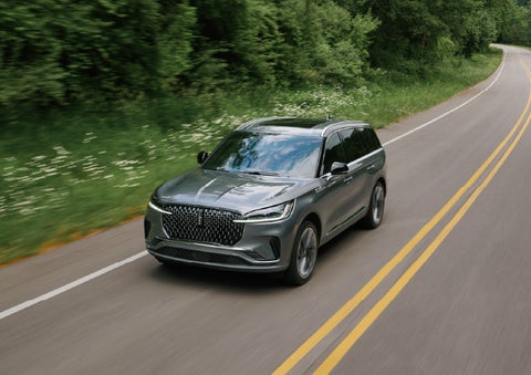 A 2027 Lincoln Aviator® SUV is being driven down a road. | Krenzen Lincoln in Duluth MN