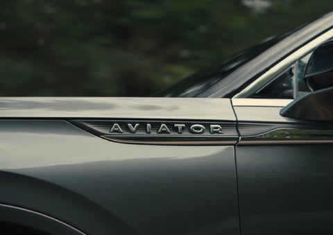 The driver’s side door and fender badging of a gray 2027 Lincoln Aviator® SUV are showcased. | Krenzen Lincoln in Duluth MN